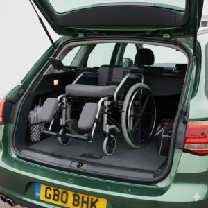 A reclining wheelchair with elevating legrests folded down for easy and compact storage in a UK car boot.