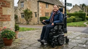 A person sitting comfortably in a rear wheel drive powerchair with adjustable headrest and pressure-relieving cushions.