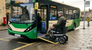 A long range electric wheelchair navigating a low-floor bus ramp in a British town, showing its suitability for UK public transport.