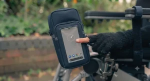 A touchscreen-compatible phone pouch pocket on a wheelchair-mounted bag.