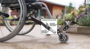 Caregiver adjusting the height settings on adjustable wheelchair anti-tippers in a British domestic setting.