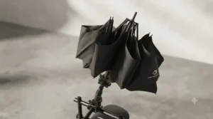 A compact, foldable windproof mobility umbrella shown half-closed for easy storage when indoors.